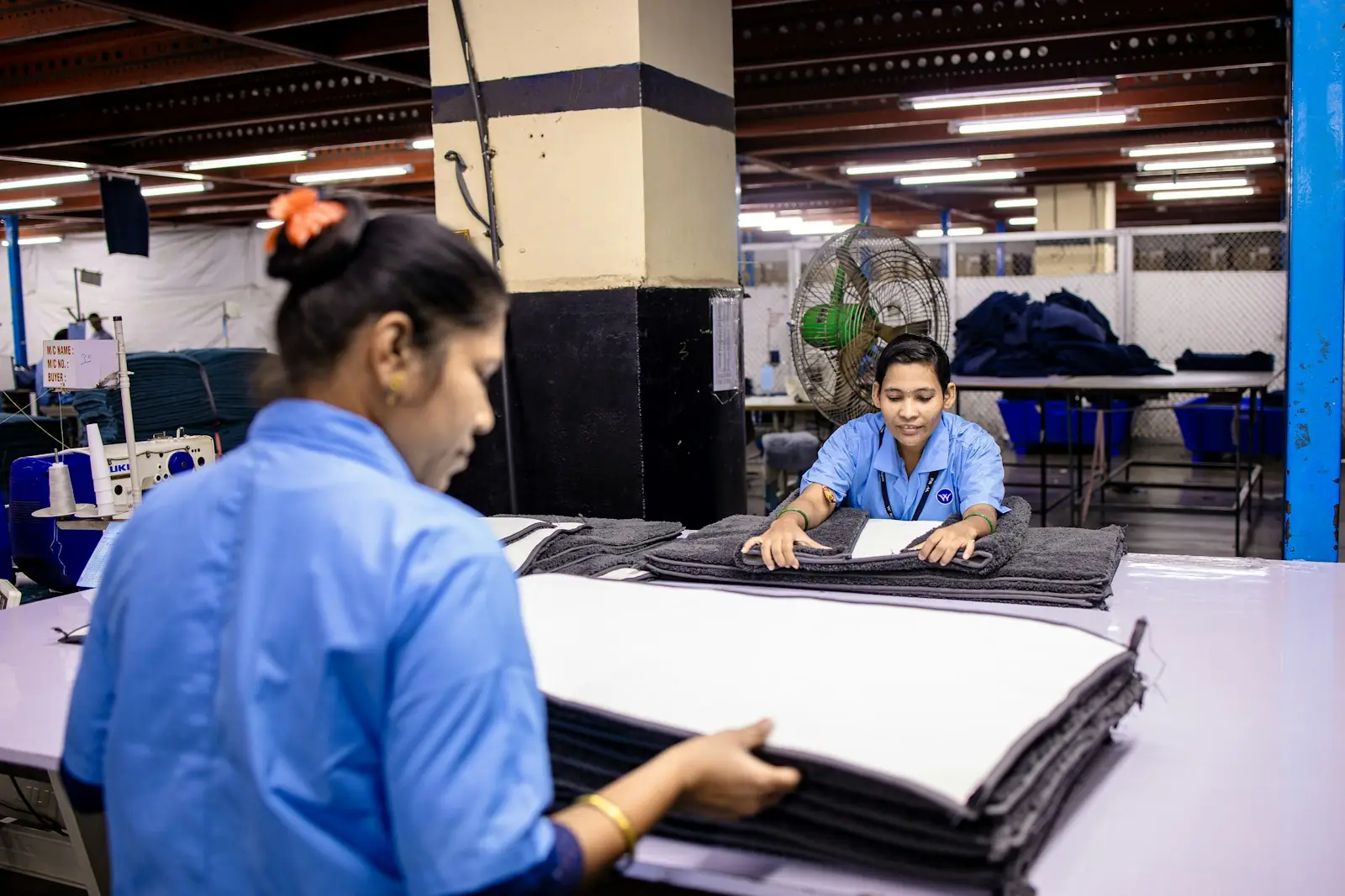 Factory workers folding fabric in a garment factory