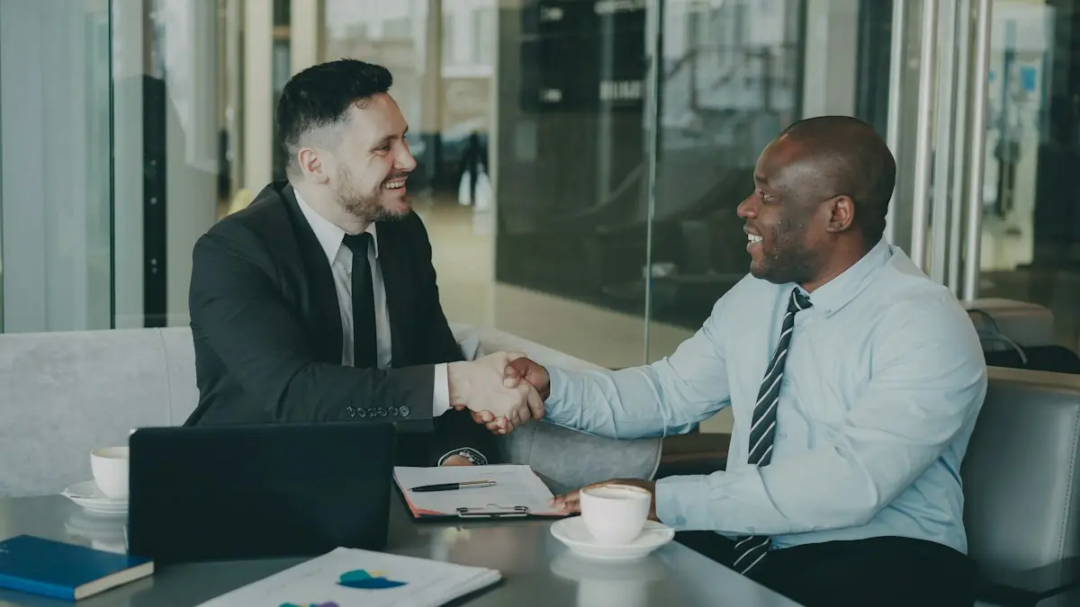 Two business people shaking hands across a table