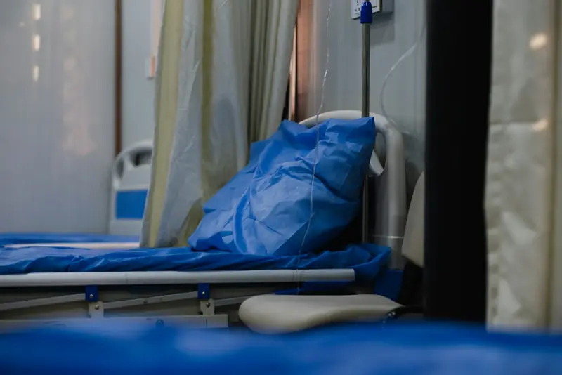 Hospital bed made with sheets and a blanket