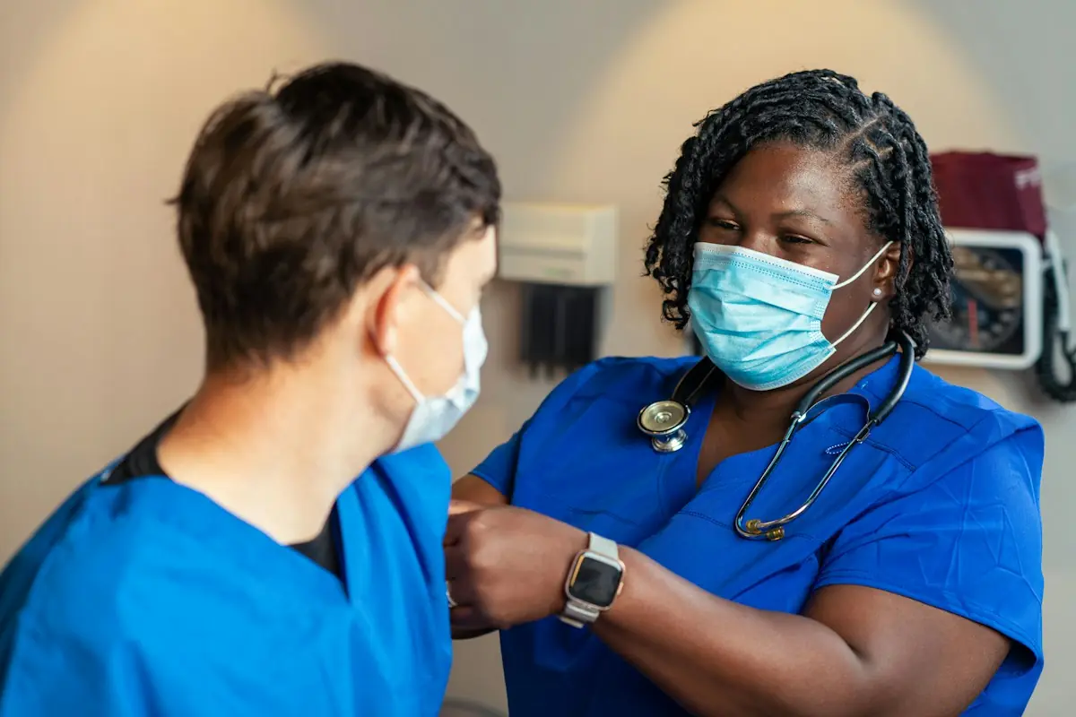 Two healthcare workers in blue scrub suits